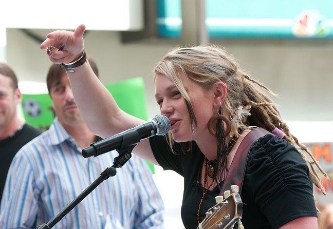 Crystal Bowersox black top, dreadlocks, bracelets, wooden hoop earrings, guitar