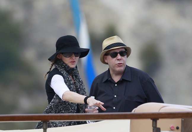 Madonna, sunglasses, black hat, braids, black tshirt, white long sleeved shirt, black wristband