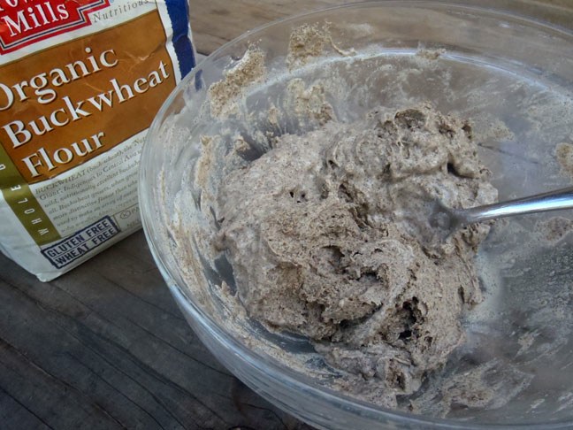 buckwheat pizza dough being mixed in a large clear bowl