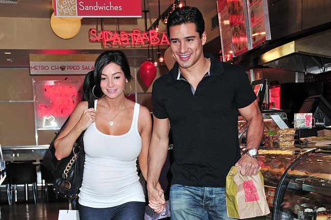 Mario Lopez, black polo, jeans, watch, Courtney Mazza, white tank top, hoop earrings, black tote, black bag, leggings, necklace