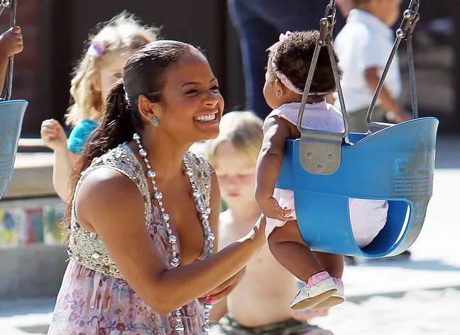 Christina Milian, sun dress, floral dress, silver beaded necklace, ponytail, park, swings