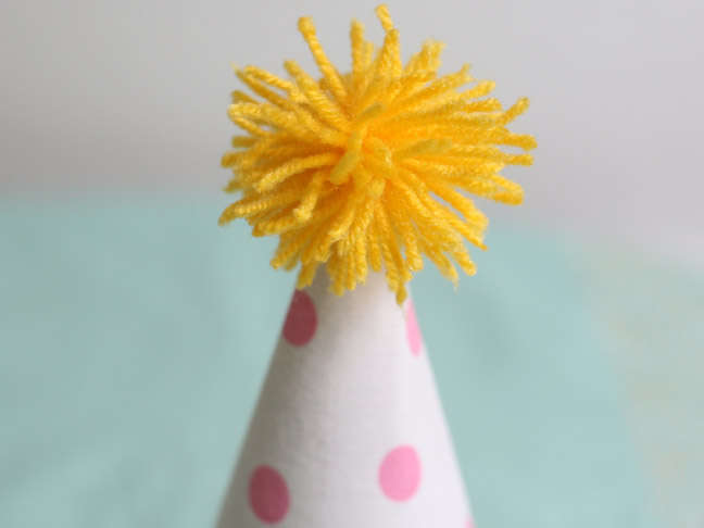 attach the pompom to the party hat