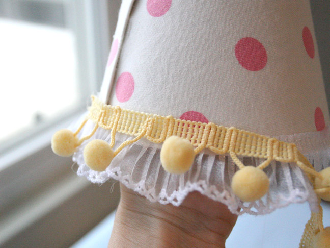 white lace and a yellow pompom trim is added to the party hat