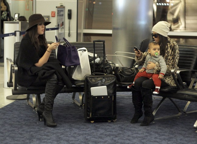 Khloe Kardashian, purple purse, black coat, Kourtney Kardashian, leopard print coat, hat,