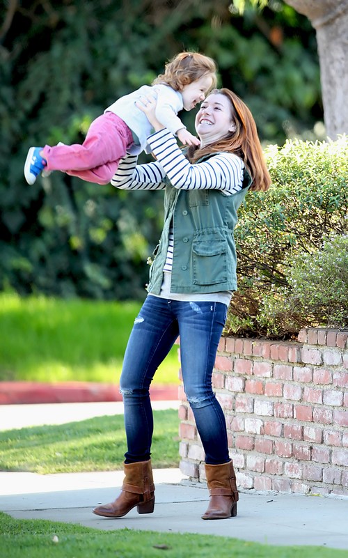 Alyson Hannigan, jeans, brown boots, green vest, striped shirt