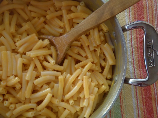 macaroni served in a cast iron pot with a wooden serving spoon