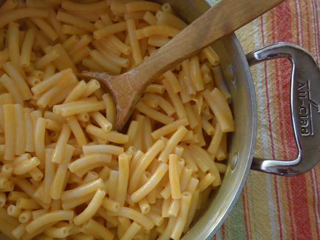 macaroni served in a cast iron pot with a wooden serving spoon