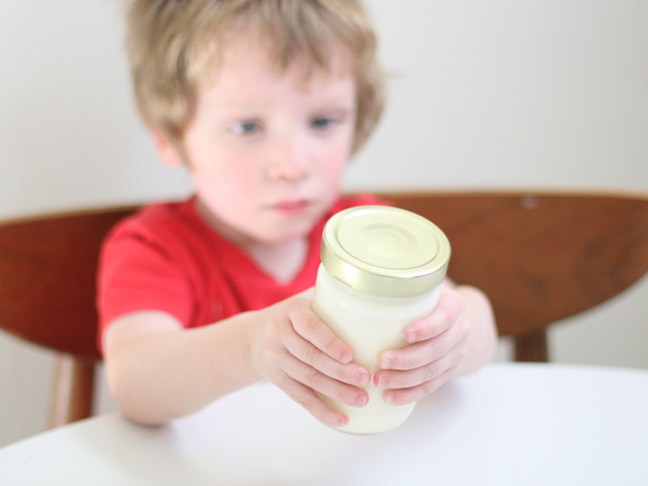 child holding mason jar
