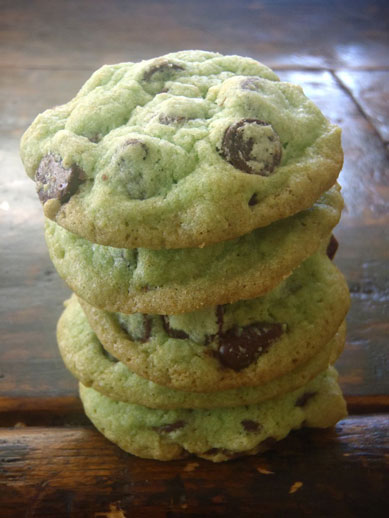 A stack of five chocolate chip cookies with a subtle green tint