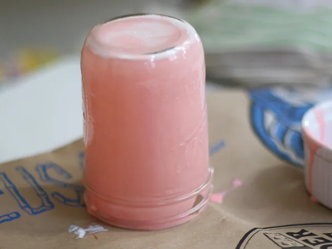 a upside down mason jar coated with a semi-opaque milky pink material coating the inside