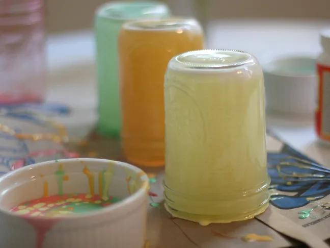 mason jars coated with a opaque mint green, orange and yellow substance on the inside