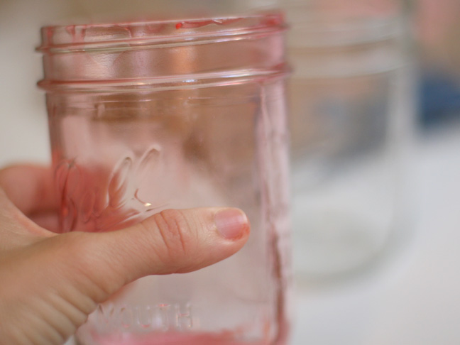 holding a pink tinged mason jar