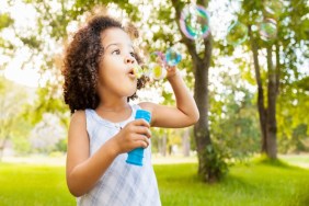 Little girl blowing bubbles