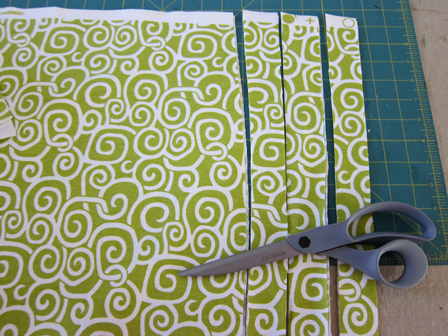 cutting the green spiral fabric in to strips with scissors