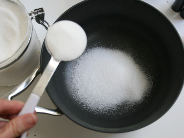 scooping sugar in to a grey pan