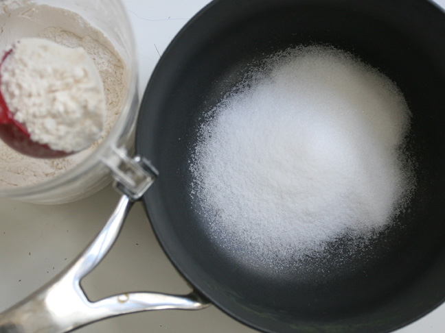 adding flour to the sugar in the pan