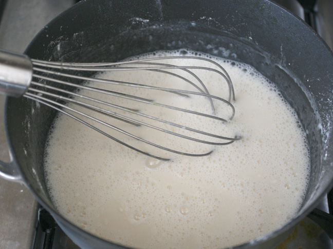 whisking a white gooey mixture together in the pot