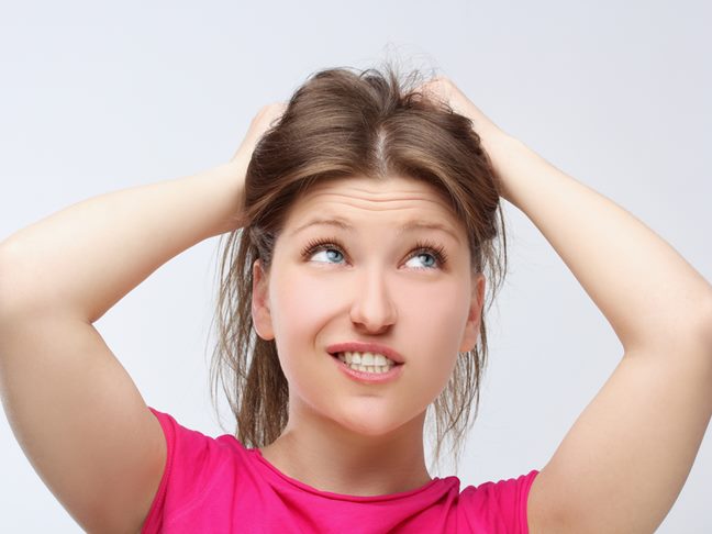 Exasperated woman holding her hair up in frustration