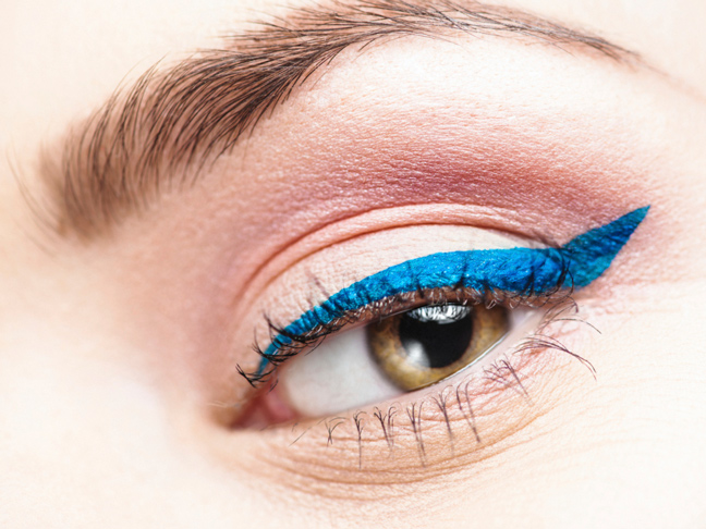 a close up of an eye with matte electric blue winged liner