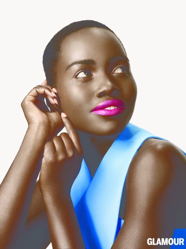 Lupita Nyongo in a blue sleveless blouse and bright fuschia lips