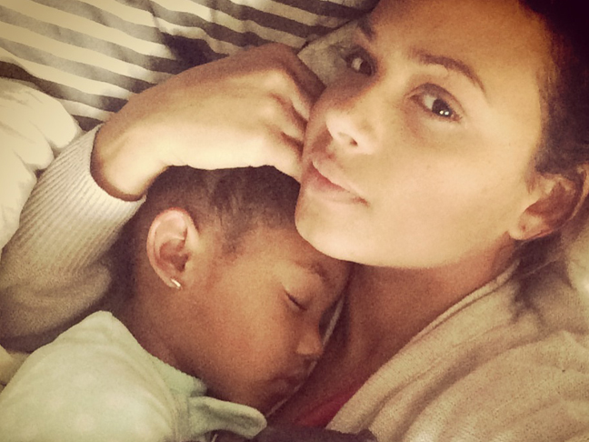 Christina Milian without makeup laying in bed with her child