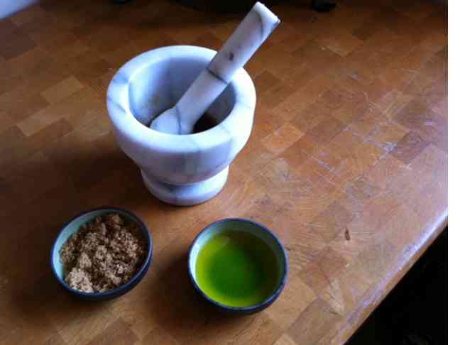 mortar and pestle pictured with bowls of sugar and olive oil