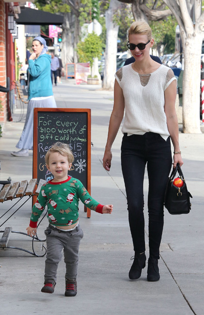 January Jones in a white blouse and sunglasses with her son