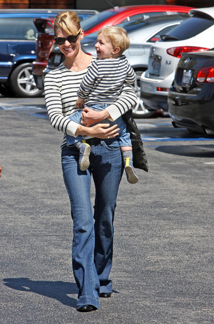 January Jones pictured holding her son in jeans and a striped shirt