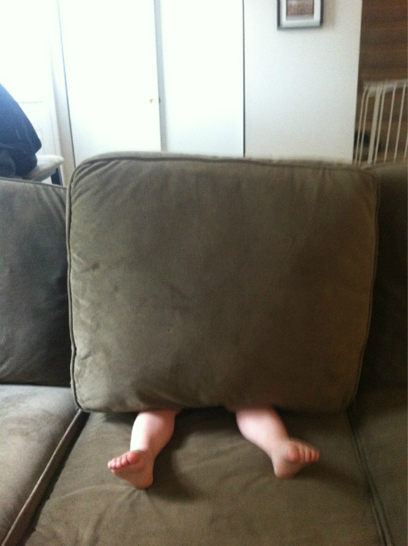 child hiding behind a pillow