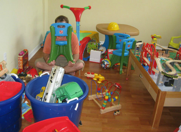 Man sitting on floor hiding behind toy