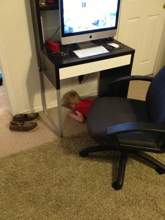 child face planting under desk