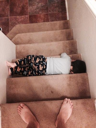 child laying flat on stairs