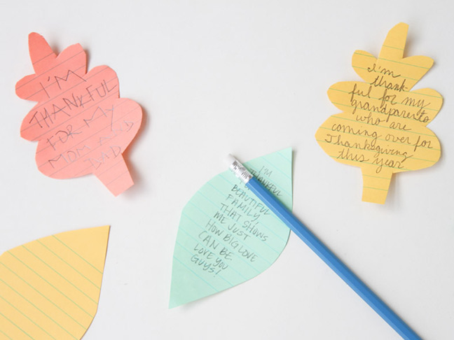 Write messages on paper leaves for Thanksgiving