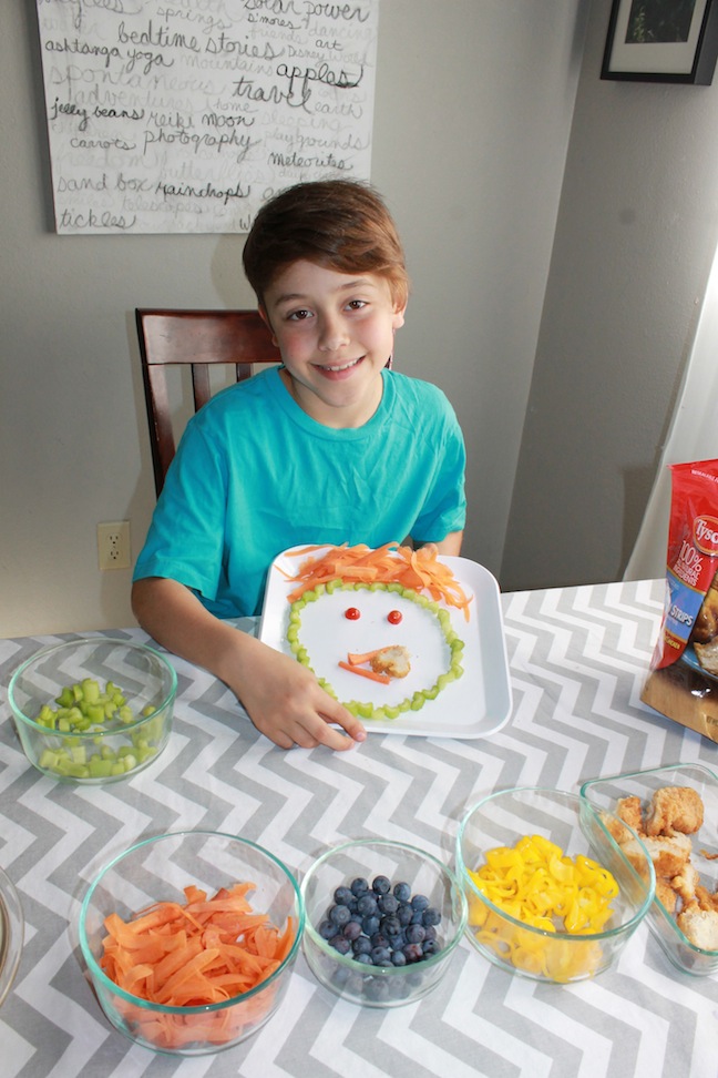 Boy showing off funny food face plate