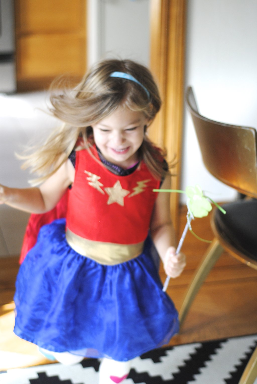 little girl running in superhero outfit