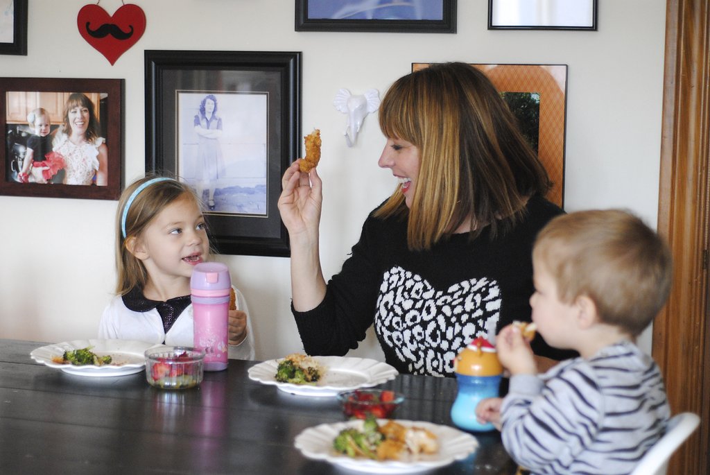 mom with kids laughing while eating dinner