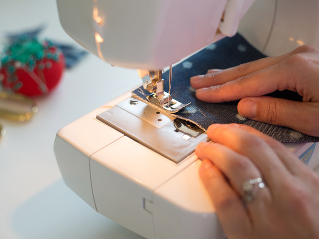 sewing-machine-hands-polka-dot-denim-fabric