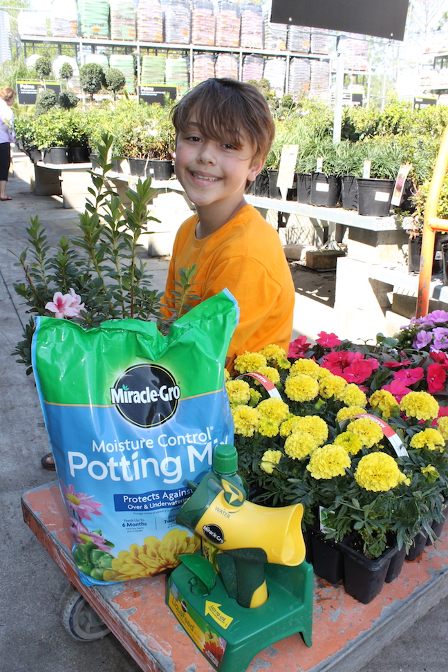 boy sitting next to flowers