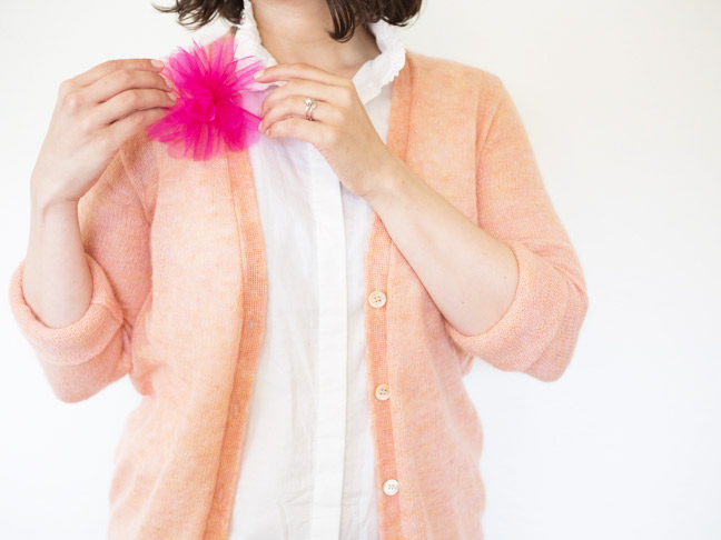 pink-flower-pouf-pin-peach-sweater-hands