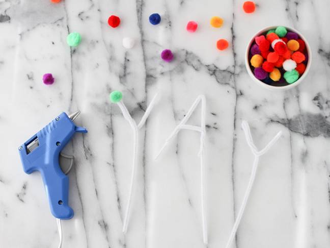 gluing pom poms to pipe cleaners