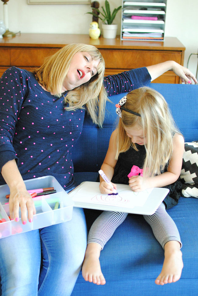 mom asleep on couch while kid draws