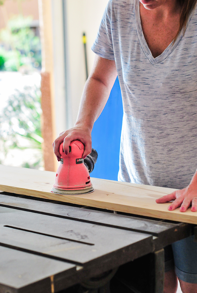 sanding and staining wood to create industrial wall shelves