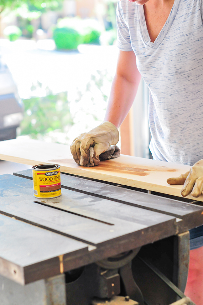 sanding and staining wood to create industrial wall shelves