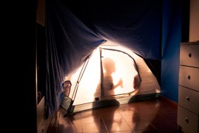 Children camping inside the house in a tent