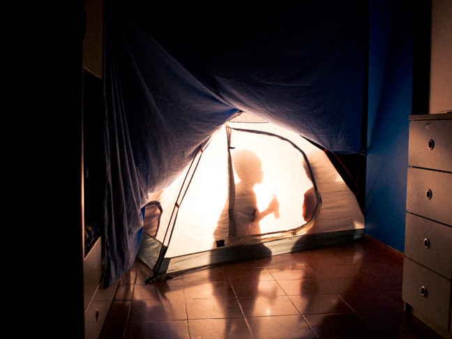 Children camping inside the house in a tent