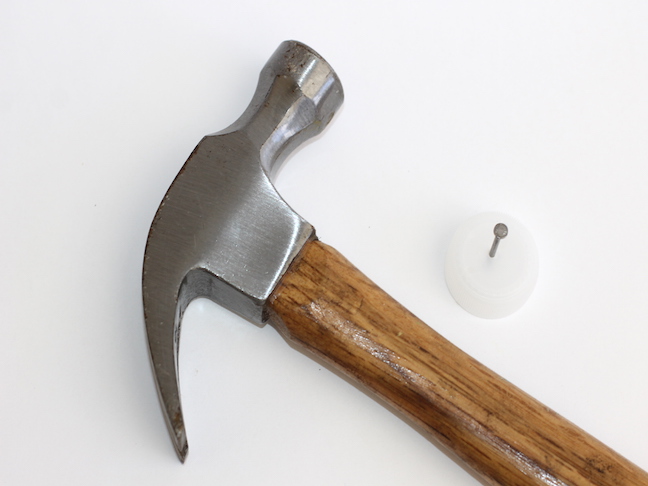 hammer with nail in bottle cap
