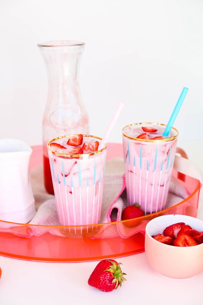 two glasses of iced pink drink with strawberries