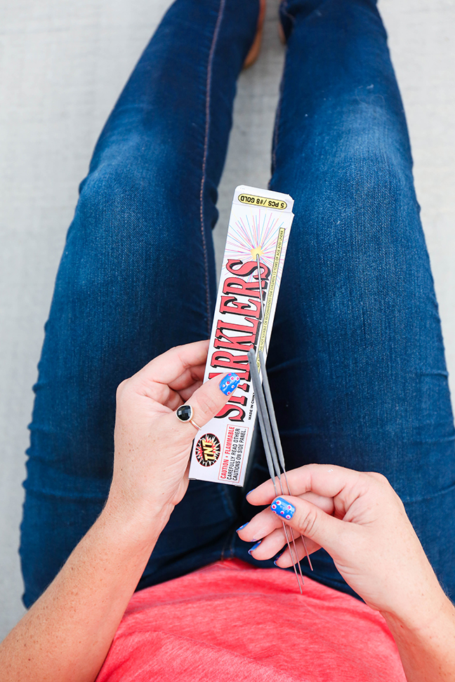 woman in jeans holding sparklers