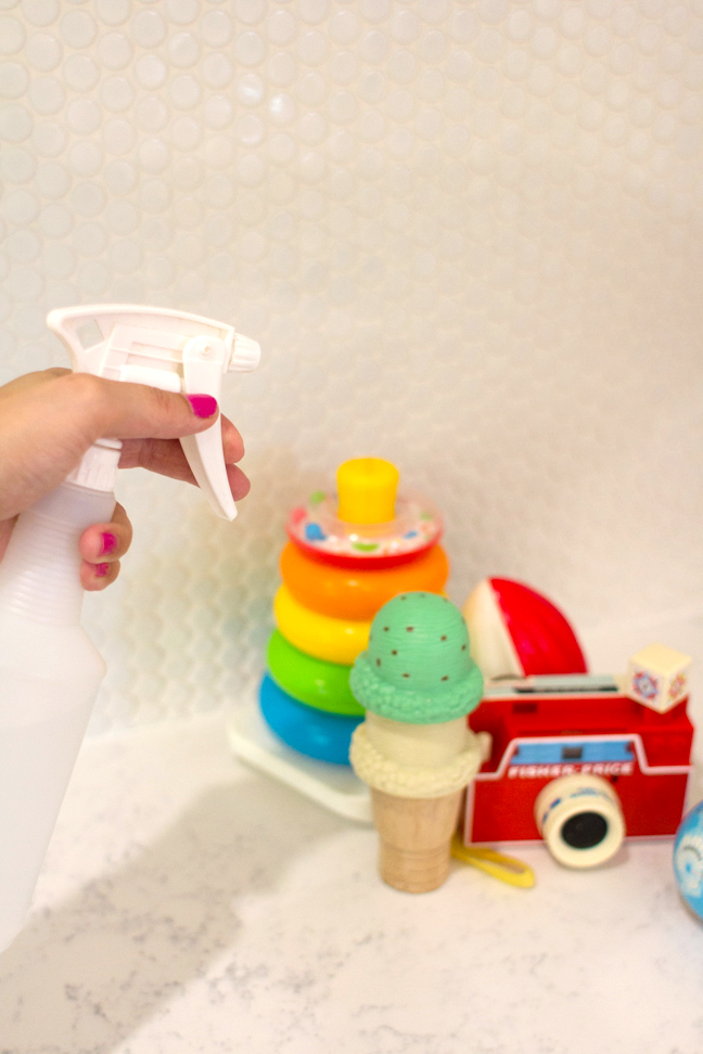hand-spraying-nontoxic-cleaning-solution-on-toys