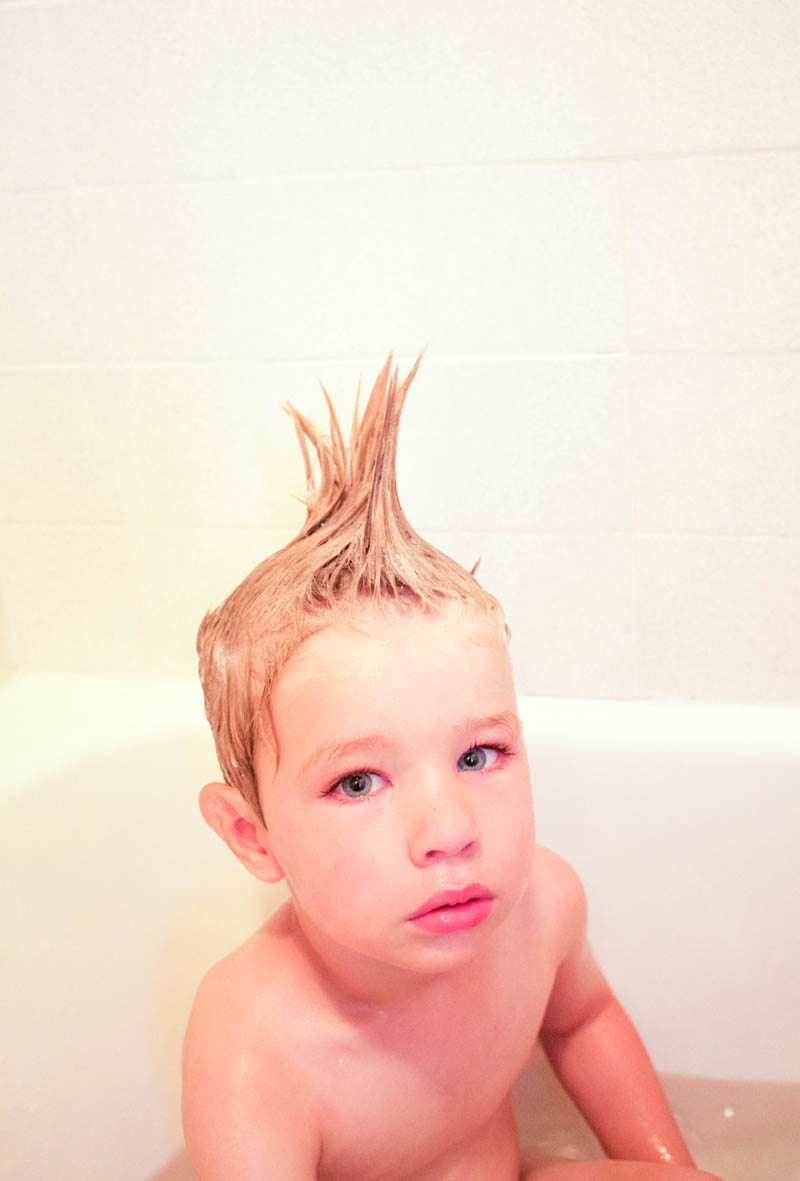little boy with mowhawk in bathtub